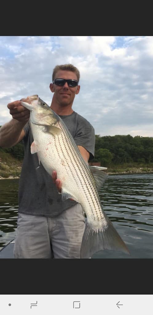 Terry Kasper on the water with a striped bass.